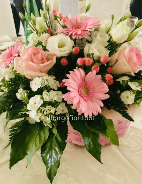 Cesto con fiori freschi, gerbere e rose colore rosa. 